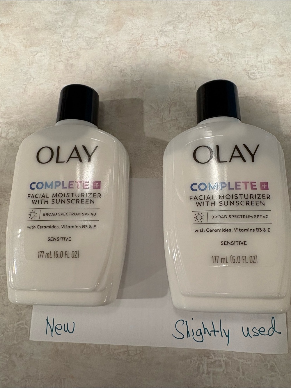 OLAY Complete+ Facial Moisturizer with Sunscreen — White bottles with Black caps